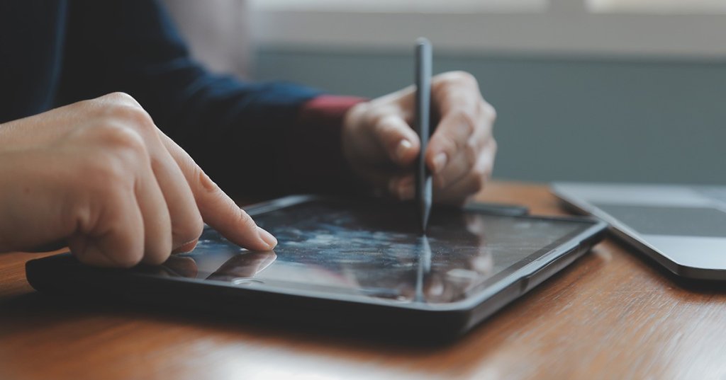 Ein Mann unterschriebt digital mit Stift auf einem Tablet.