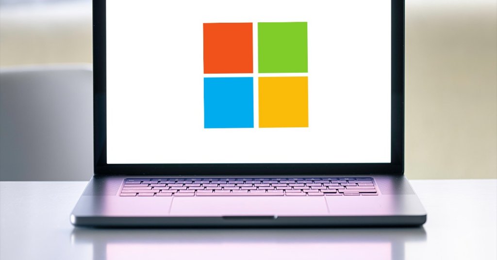 Microsoft-Logo auf dem Bildschirm eines eingeschalteten Laptops.